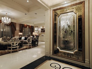 玄關-以極盡華麗的詮釋手法，融入細膩雕花圖樣，透視鑲銅玻璃的水波紋，浮現微妙光影的游移之間，更見設計總監黃庭芝對迎賓氛圍的重視。